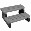 Two-tier hot tub stairs with wide steel-grey treads, rounded corners and long narrow slots, supported by black legs with an open gap between steps