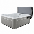 A gray and white outdoor hot tub with the pro lifter cover lifter shows open revealing the interior jets and back panel, on a solid white background.